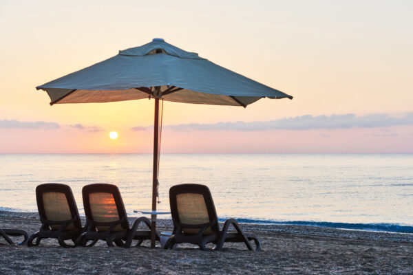 A serene sunset on the beach, highlighting the beauty of nature while reminding to protect furniture from sun damage.